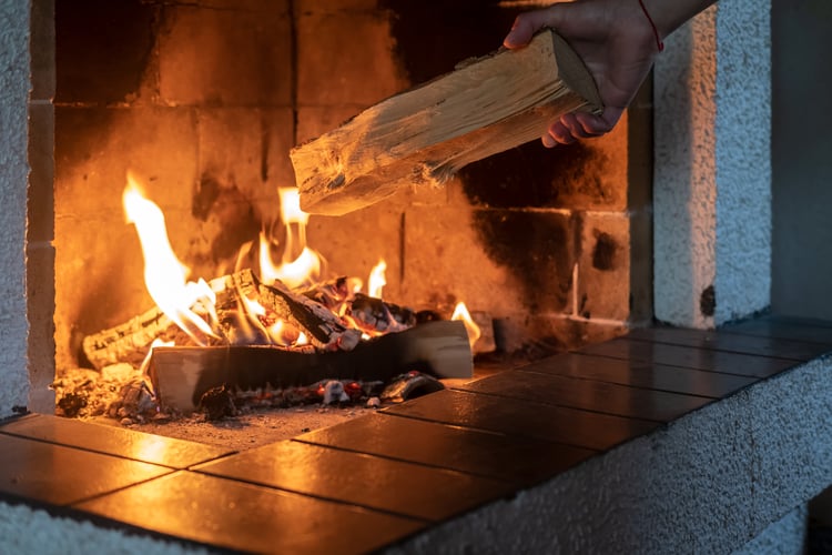 Adding firewood in fireplace