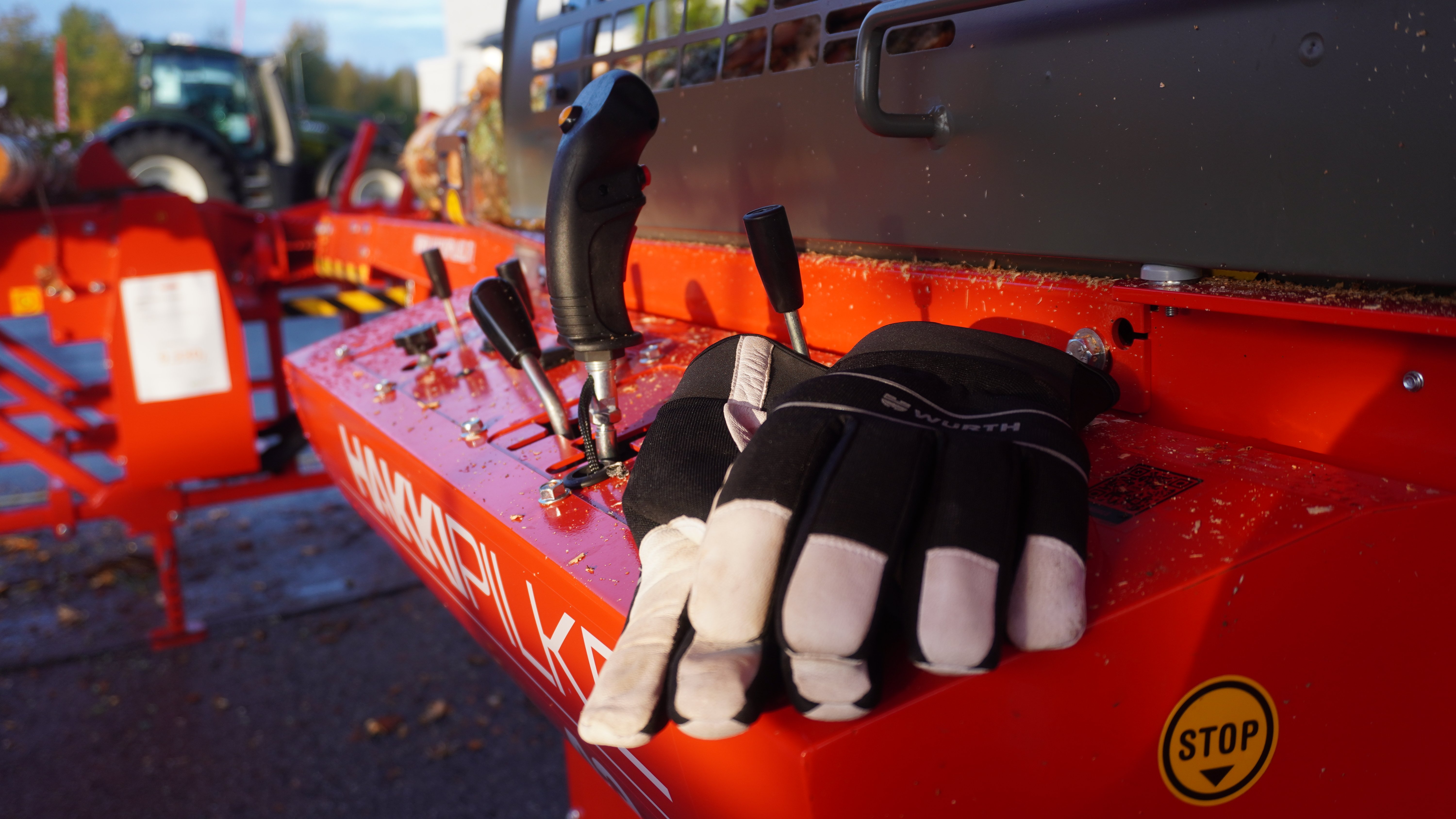 A picture of work gloves laying on top of the control panel of a firewood processor